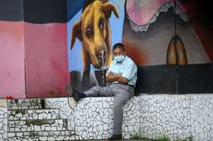 A man rests in a park after the government eased lockdown measures after five months of quarantine in San Salvador on August 24, 2020. By MARVIN RECINOS (AFP)