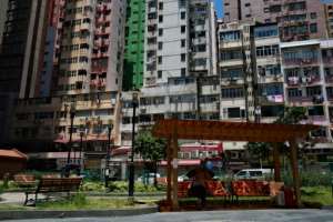 A man sits on a park bench partially cordoned off to enforce social distancing in Hong Kong. By Anthony WALLACE (AFP)