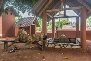 A man sleeps on a bench next to a voodoo idol in Porto-Novo. The city's old quarter has dozens of 'voodoo squares' that were set up by families who settled from the 16th century and established temples and divinities around their houses. By Yanick Folly (AFP)