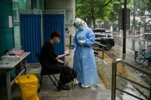 A medical worker prepares to test a man for the COVID-19 novel coronavirus in Wuhan, China. By Hector RETAMAL (AFP)