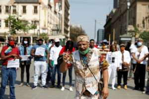 A member of the Khoisan community speaks before joining a protest march under the banner of