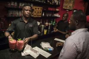 A barman at the Republic Bar & Grill in Accra serves a Kokroko cocktail, a drink made of Sobolo and Akpeteshie.  By CRISTINA ALDEHUELA (AFP)