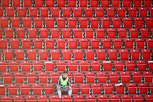 A Bayern Munich substitute player wearing a protective face mask maintains social distance in the stands during a match against FC Union Berlin played without fans. By HANNIBAL HANSCHKE (POOL/AFP)