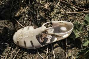 A blood-stained sandal lies next to the grave of an alleged victim of a massacre that unfolded in the Tigrayan town of Mai Kadra November 9. By EDUARDO SOTERAS (AFP)