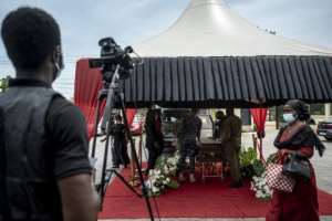 A cameraman films pallbearers carrying a coffin during a funeral ceremony in Accra. By CRISTINA ALDEHUELA (AFP)