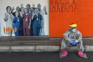 A Colombian health worker takes a break outside Medellin's General Hospital, amid the COVID-19 pandemic. By JOAQUIN SARMIENTO (AFP)
