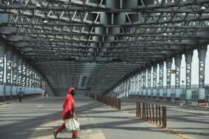 A commuter walks past the deserted Howrah Bridge during a day-long state-imposed lockdown as a preventive measure against the surge in Covid-19 cases in Kolkata, India. By Dibyangshu SARKAR (AFP)