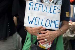 A demonstrator holds a placard reading 'Refugees welcome' during the Citizen and Solidarity March in Paris in support of migrants and refugees. By Thomas SAMSON (AFP)