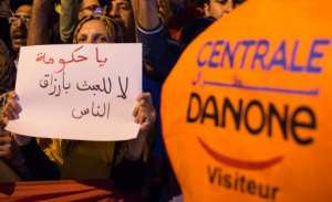 A demonstrator holds a sign as employees of the company Centrale Danone, a subsidiary of French multinational Danone, protest in front the parliament in Rabat on June 5, 2018, against the boycott of the brand in Morocco.  By Fadel SENNA (AFP/File)