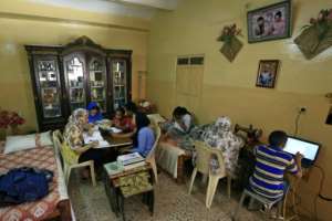 A family studies together at home in Khartoum. By Ashraf SHAZLY (AFP)