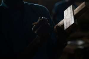 A former child soldier on a carpentry course draws a cutout on a piece of wood. By FLORENT VERGNES (AFP)