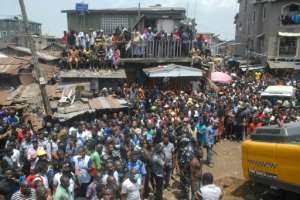 A frenzied crowd gathered at the site of the collapse, digging out rubble with bare hands before emergency teams and machines arrived. By SEGUN OGUNFEYITIMI (AFP)