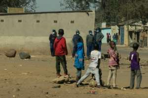 A group of children look on as a team of police are deployed in Mbare township following a ban on anti-government protests last month. By Jekesai NJIKIZANA (AFP/File)