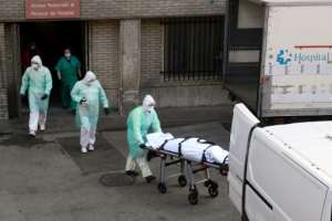 A health worker carries a body on a stretcher outside Gregorio Maranon hospital in Madrid. By OSCAR DEL POZO (AFP)