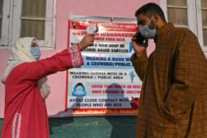 A health worker checks the temperature of a voter in India's Kashmir state. By TAUSEEF MUSTAFA (AFP)