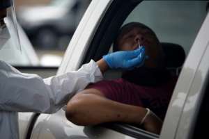A health care worker administers a COVID-19 test at United Memorial Medical Center testing site in Houston, Texas -- now only the third state to register more than 10,000 virus cases in a 24-hour period. By Mark Felix (AFP/File)