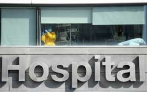 A healthcare worker looks out the window of La Paz hospital, in Madrid, as Spain's health minister calls on residents of the city to limit their movements and social contacts to the
