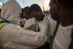 A Italian doctor inspects a migrant who was rescued by the Aquarius rescue ship in August