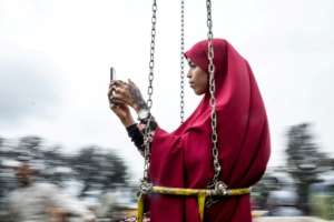 A Kenyan Muslim woman takes a selfie on a fairground ride at the Sir Ali Muslim Club in Nairobi after prayers on Muslim holiday of Eid al-Fitr. By Yasuyoshi CHIBA (AFP/File)