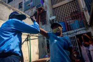 A Luanda resident celebrates with a policeman after the Angolan National Director of Public Health lifted a two week virus quarantine order. By OSVALDO SILVA (AFP)