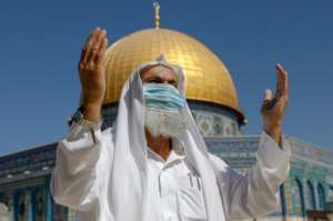 A Palestinian man prays in front of the Dome of the Rock in Jerusalem as Israel lifts some restrictions. By Ahmad GHARABLI (AFP)