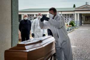 A pallbearer takes a picture of a coffin for the relatives of someone who has died, at a cemetery in the Italian province of Bergamo. By Piero CRUCIATTI (AFP)