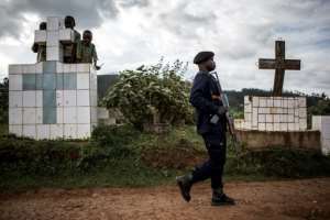 A police officer escorts the coffins of two Ebola victims ahead of their burial in a graveyard in Butembo. By JOHN WESSELS (AFP/File)