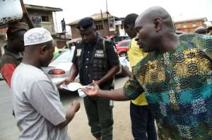 A policeman in Lagos distributes flyers about measures to prevent coronavirus. By PIUS UTOMI EKPEI (AFP)