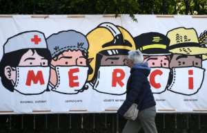 A poster in Paris thanks healthcare workers, shopkeepers, police, the post office staff and farmers. By FRANCK FIFE (AFP)