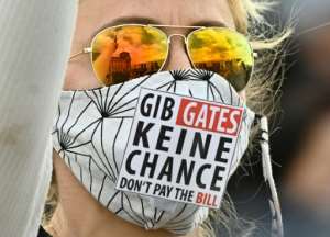 A protester at a rally in Berlin wearing a mask saying