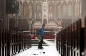A staff member sprays disinfectant as part of preventive measures against the spread of the COVID-19 coronavirus, at Myeongdong Catholic Cathedral in Seoul. By - (YONHAP/AFP)