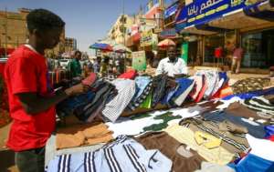 A street vendor displays shirts at a market in the Sudanese capital Khartoum. By ASHRAF SHAZLY (AFP)