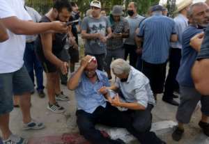 A supporter of the Ennahda party stems his wound from a stone thrown during a protest outside the parliament building in Tunis on Monday. By FETHI BELAID (AFP)