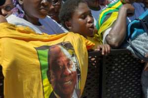 A supporter of Ramaphosa holds up a T-shirt featuring Zuma's expected successor