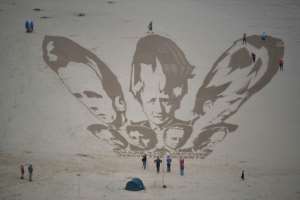 A sand drawing of the G7 leaders in Cornwall by activists who called on nations to 'share the vaccine and waive the patents'. By Ben STANSALL (AFP)