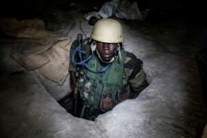 A Senegalese soldier emerges from a bunker at a captured rebel base in Blaze Forest in Casamance. By JOHN WESSELS (AFP)