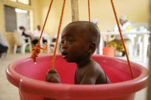 A sick child is weighed on makeshift scales at a Doctors Without Borders (MSF) clinic in Anka. By Kola Sulaimon (AFP)