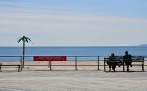 A sign reading 'Keep This Far Apart', remind speople of social distancing, is seen on the Coney Island boardwalk in New York City. By Angela Weiss (AFP)