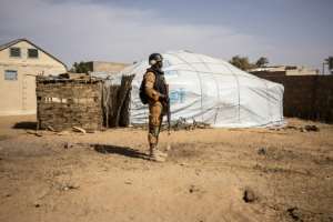 A soldier in northern Burkina Faso patrols a camp for people displaced by the violence. Five percent of the country's population has fled their home. By OLYMPIA DE MAISMONT (AFP/File)