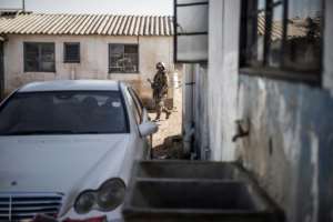 A soldier patrols as police search the hostels. By MARCO LONGARI (AFP)