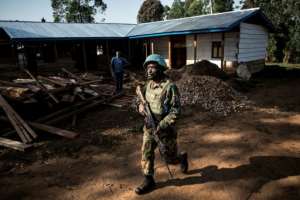 A soldier (pictured March 9, 2019) from the UN Organisation Stabilisation Mission patrols outside an Ebola Treatment Centre in Butembo, as rebel fighters in the region have dramatically complicated the response to the disease. By JOHN WESSELS (AFP/File)