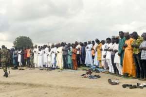 A soldier walk past Muslims as they pray near a gas station in Nigeria's Ogun State in August 2019. By PIUS UTOMI EKPEI (AFP/File)