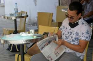 A Tunisian man reads the newspaper on the Habib Bourguiba avenue in Tunis on July 27, 2021. By FETHI BELAID (AFP)