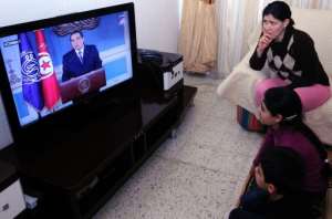 A Tunisian family watches TV on January 13, 2011 as Zine El-Abidine Ben Ali resigns as president. By Fethi Belaid (AFP/File)