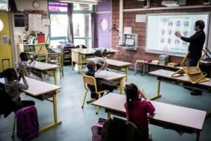 A teacher shows pupils how to clean their hands in a classroom at Saint-Exupery school in the Paris' suburb of La Courneuve. By Martin BUREAU (AFP)