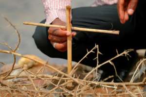 A Tigrayan refugee places a makeshift cross on the banks of the Setit River bordering Ethiopia. By ASHRAF SHAZLY (AFP)