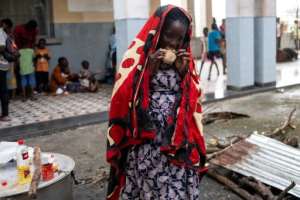 A woman eats at an emergency foodbank in Beira, Mozambique. By WIKUS DE WET (AFP)