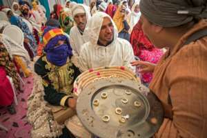 A woman hands around wedding rings on a silver-coloured platter at a group wedding of young Berber couples in the Moroccan village of Imilchil on September 21, 2019. By FADEL SENNA (AFP)