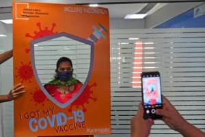 A woman has her photograph taken after getting inoculated in Mumbai. By INDRANIL MUKHERJEE (AFP)