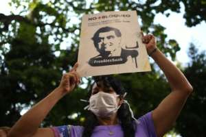 A woman holds a sign with the image of Colombian businessman Alex Saab, who was extradited to the United States, during a demonstration demanding his release in Caracas, Venezuela on October 17, 2021. By Federico PARRA (AFP)